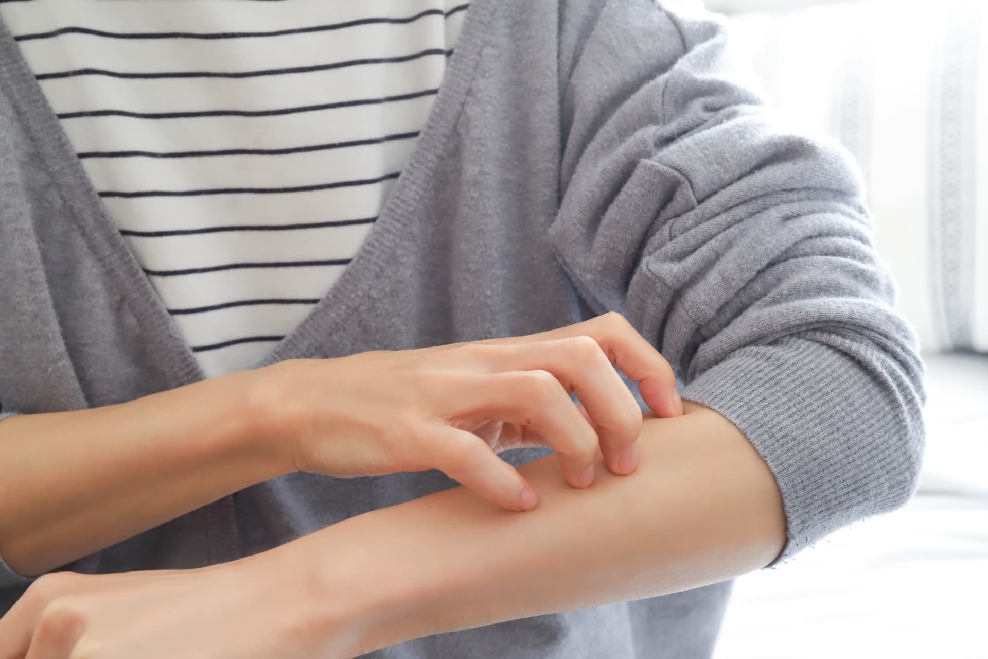 腕を搔いている人