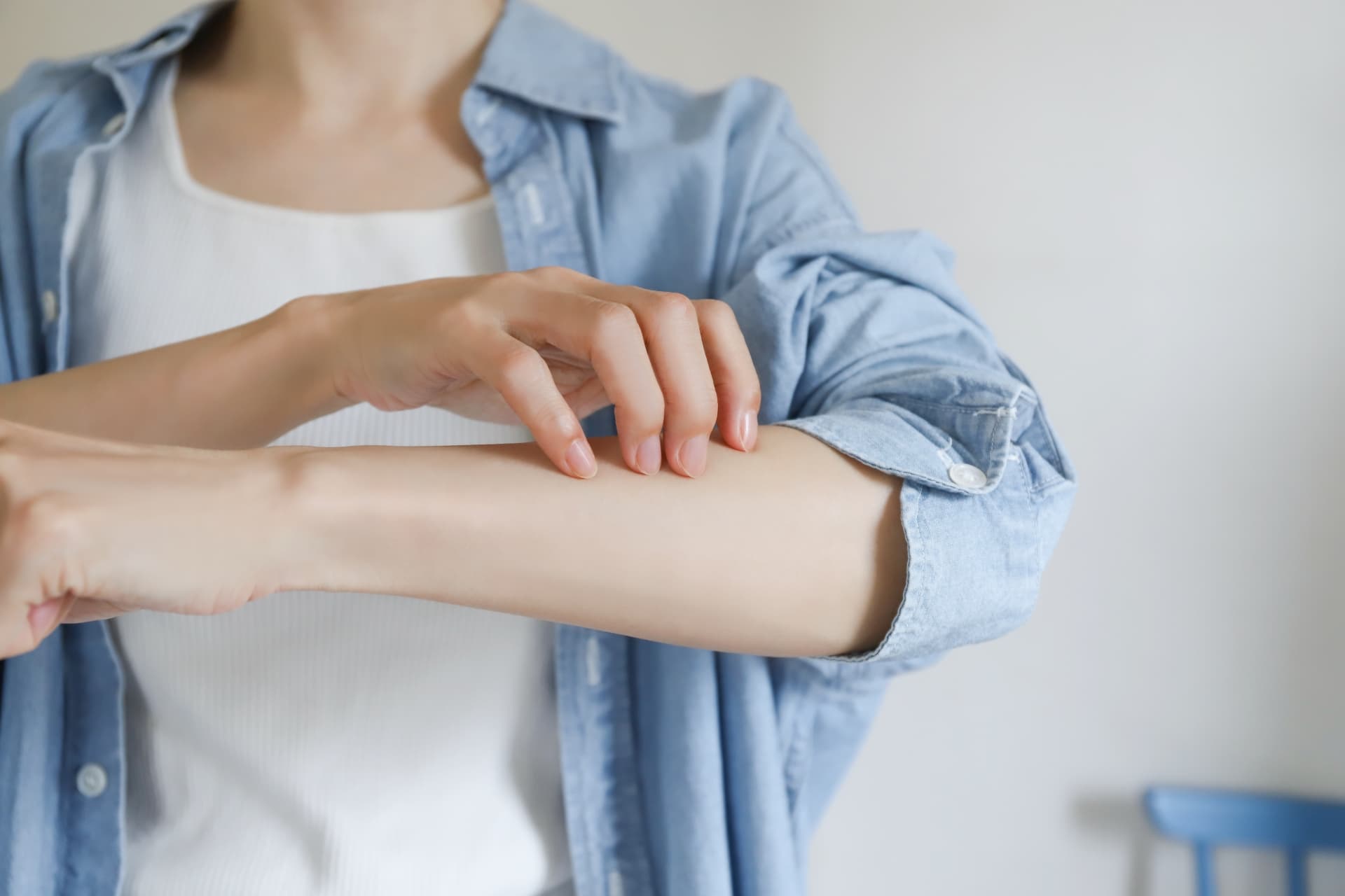 腕を掻いている人