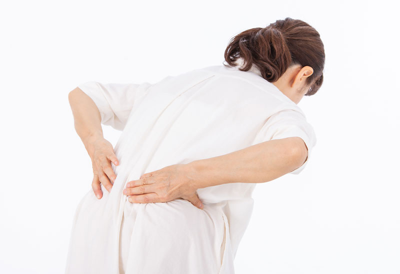 下腹部を抑え体調不良な女性