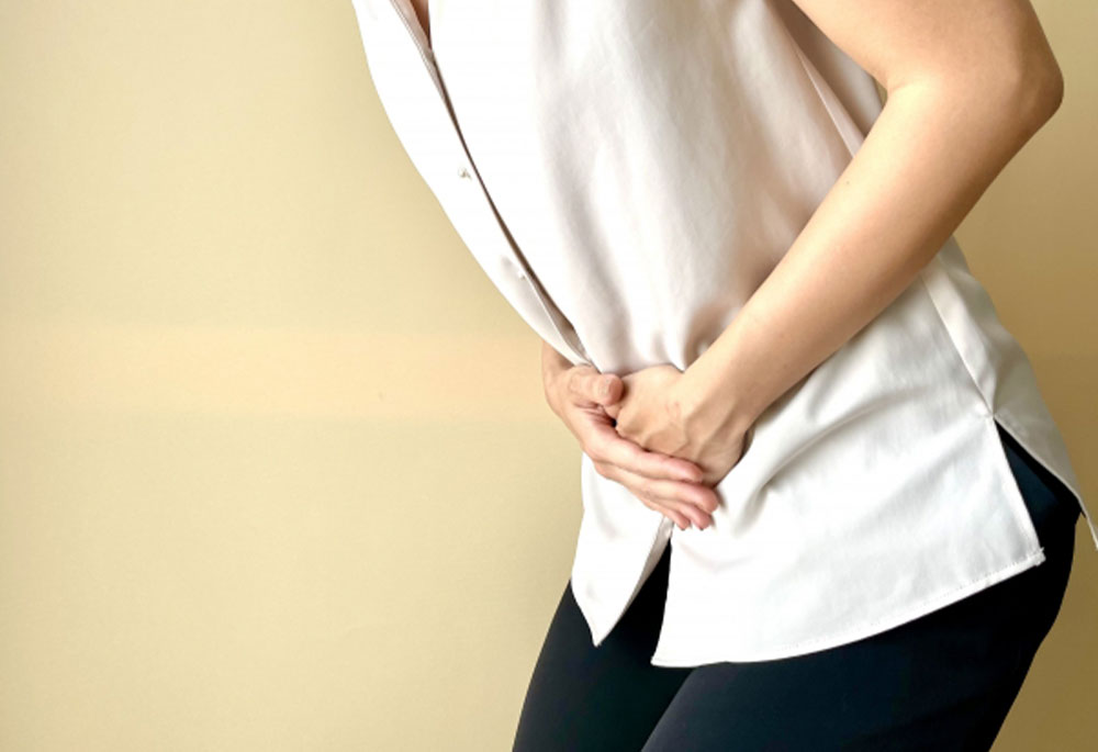 下腹部を抑え体調不良な女性