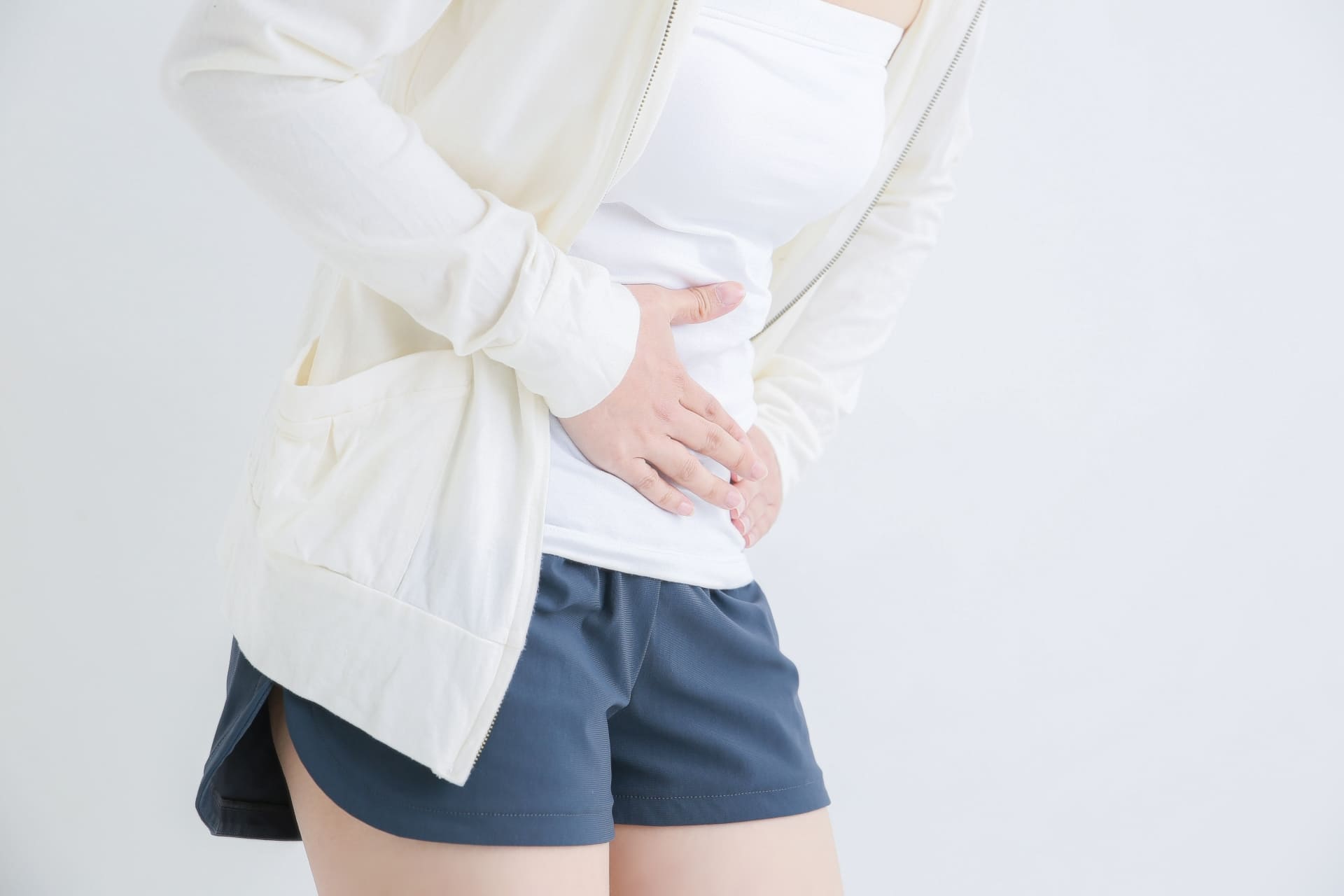 下腹部を抑え体調不良な女性